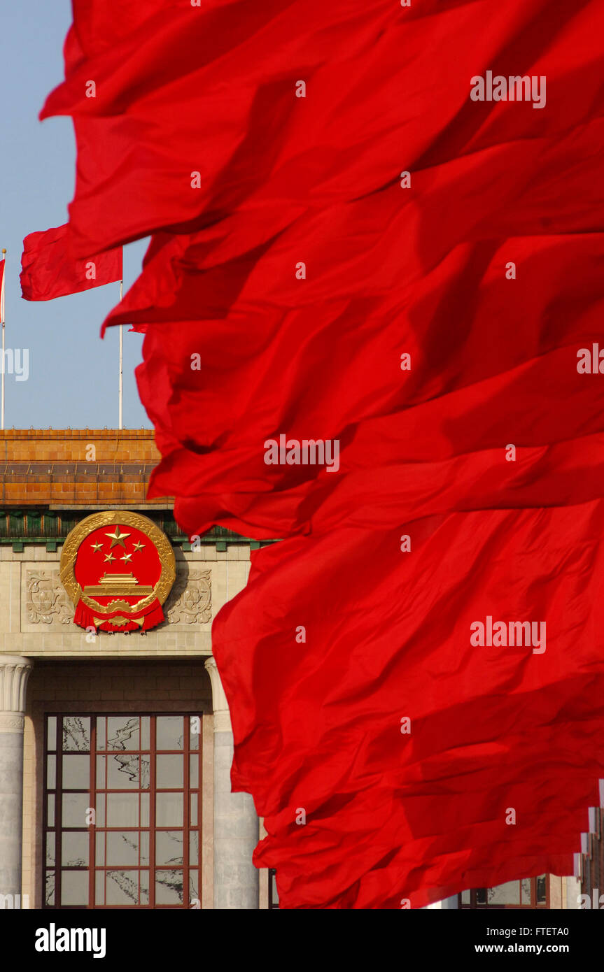 Flags fly near the national emblem at the Great Hall of the People on Tienanmen Square Stock Photo