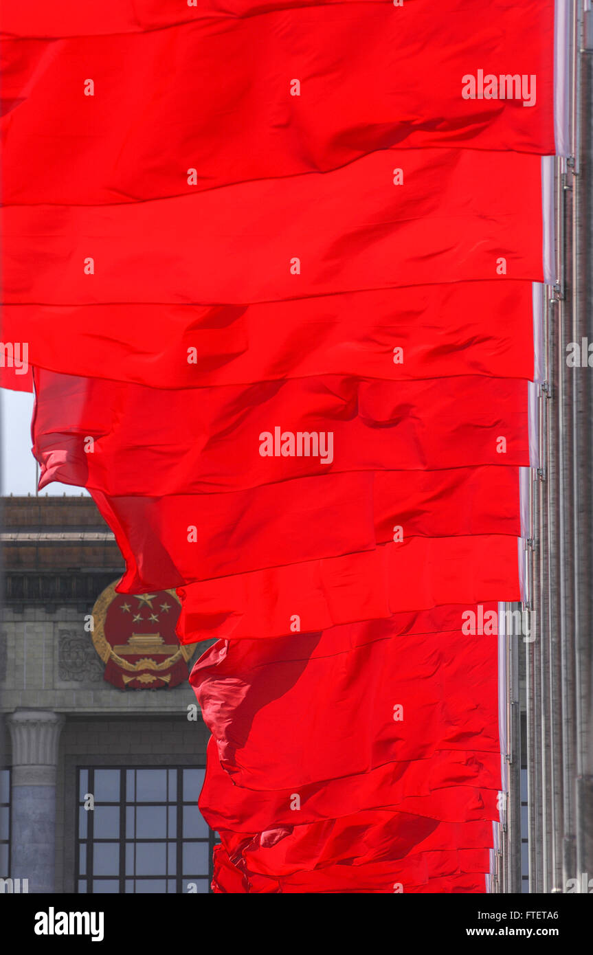 Flags fly near the national emblem at the Great Hall of the People on Tienanmen Square Stock Photo