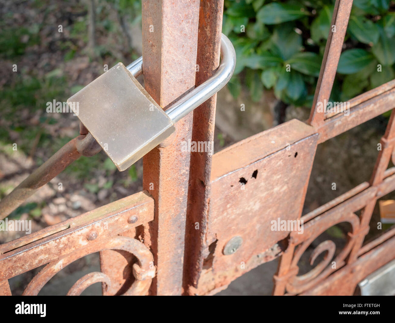 Rusty metal gate closed with padlock - concept image Stock Photo