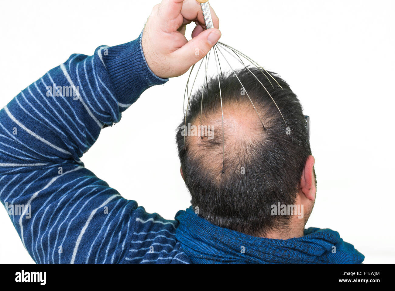 Man relaxes with the Genie head massager. Alternative Therapy. Indian head  massage tool, self head massager Stock Photo - Alamy