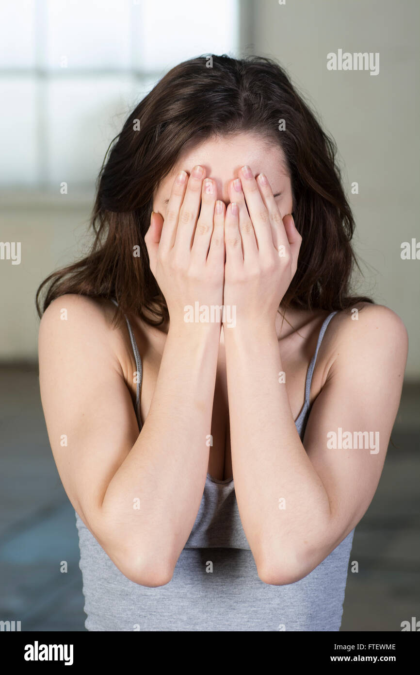 Young woman hiding face with hands Stock Photo