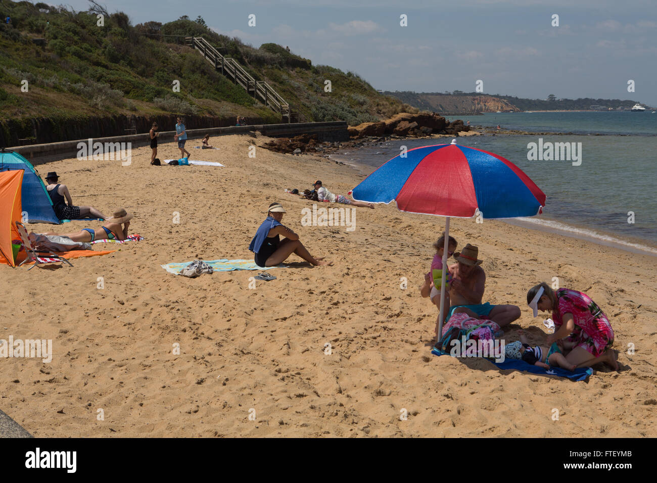 People enjoying the sunshine on the beach at Black Rock, Victoria