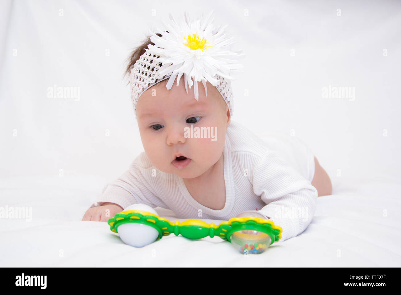 little girl lying and playing with a rattle Stock Photo - Alamy