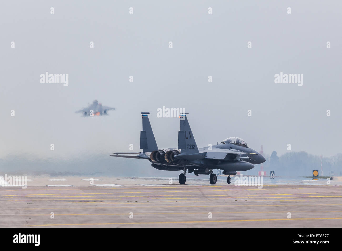 An F-15E Strike Eagle follows its colleague into the sky at RAF Lakenheath Stock Photo