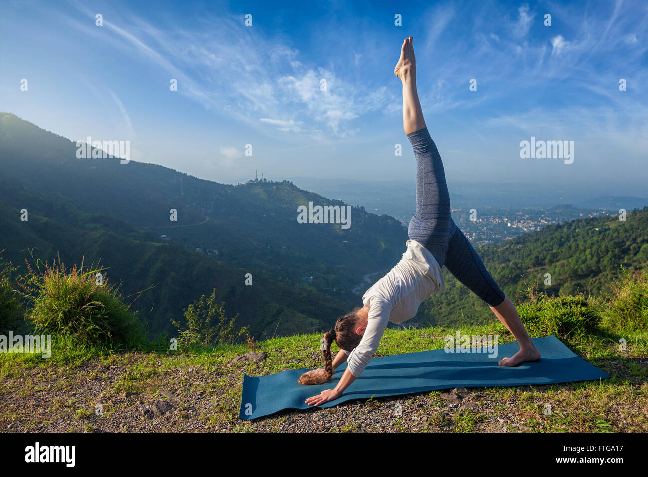 Young sporty fit woman doing yoga oudoors Stock Photo