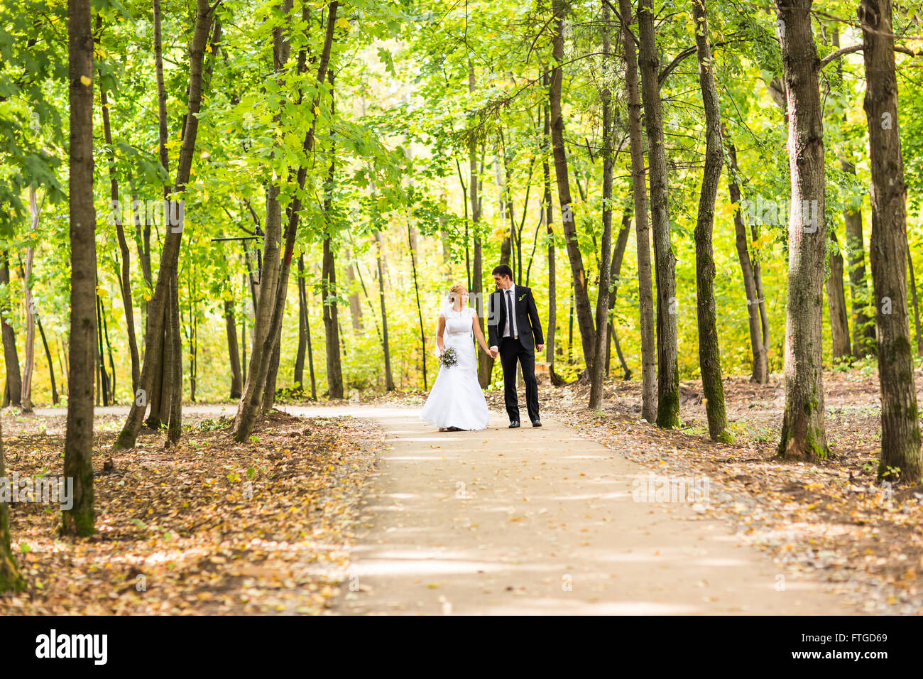 Bride and groom holding hands outdoors Stock Photo - Alamy