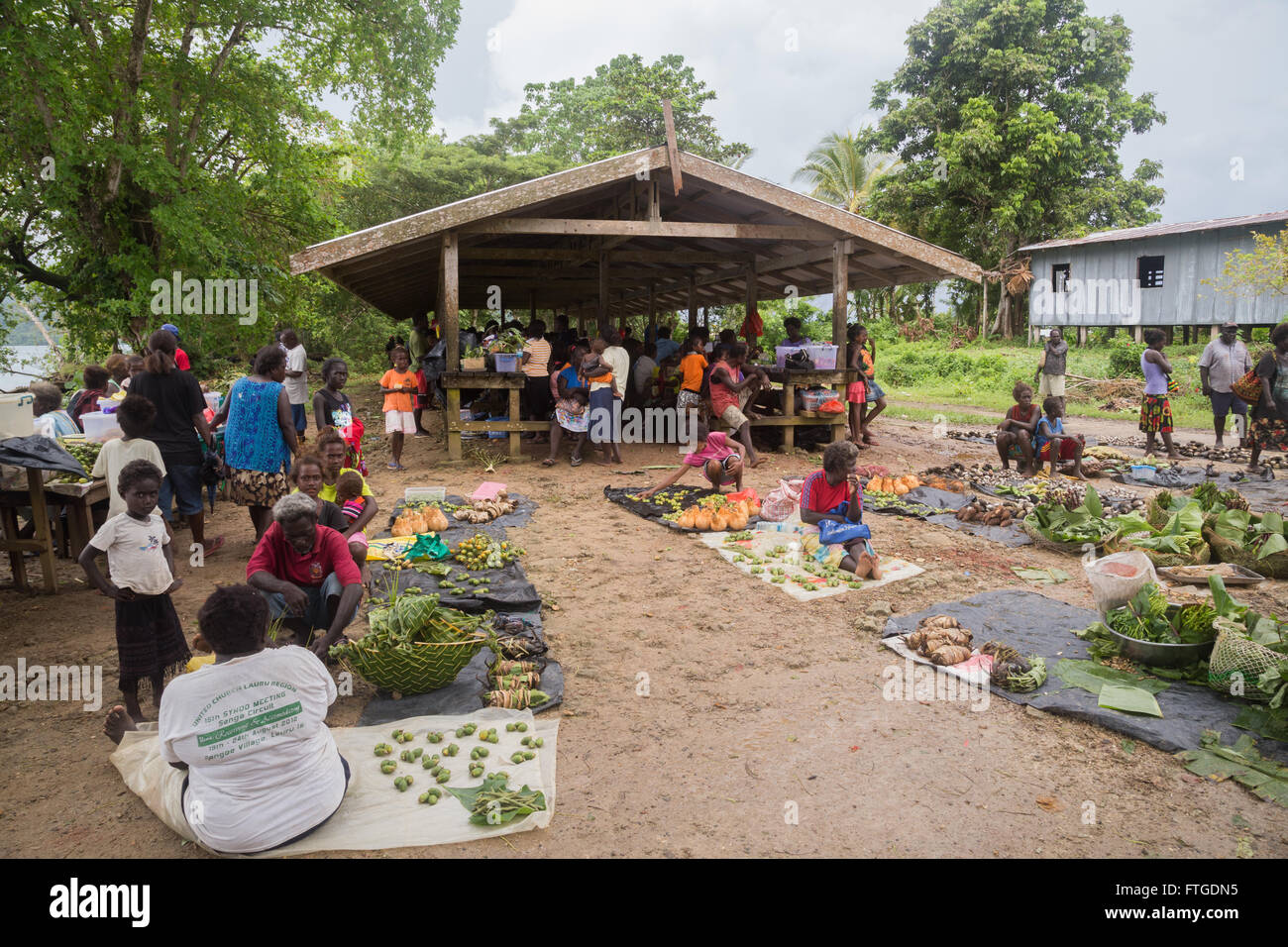 Seghe, Solomon Islands - June 16, 2015: People buying and selling food at the local market in the village of Seghe. Stock Photo