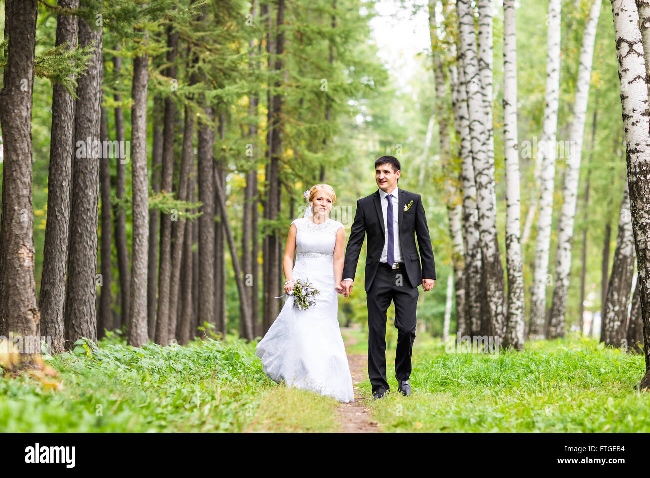 Bride and groom holding hands outdoors Stock Photo - Alamy