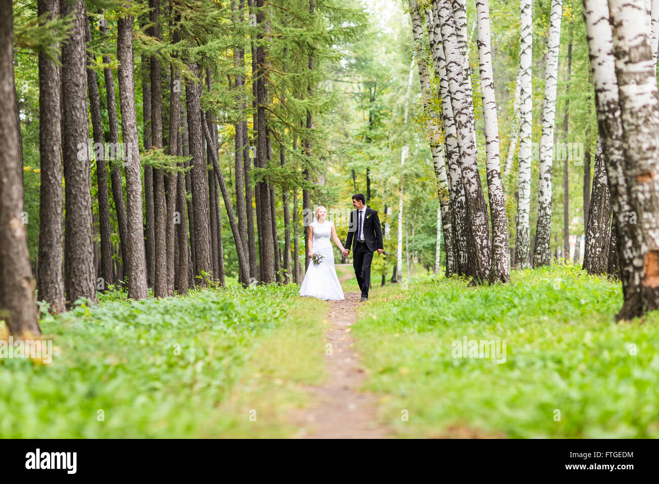 Bride and groom holding hands outdoors Stock Photo - Alamy