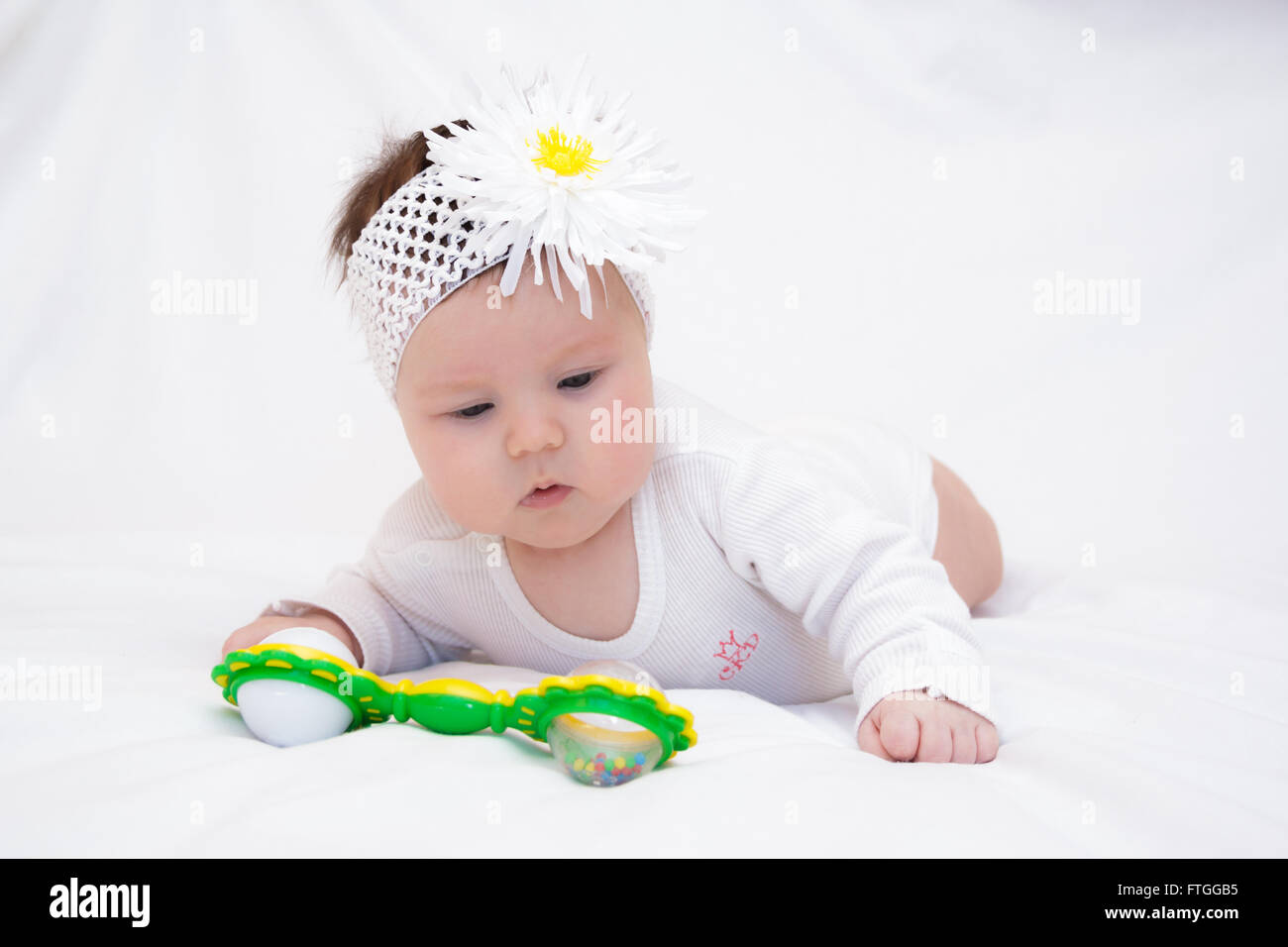 little girl lying and playing with a rattle Stock Photo Alamy