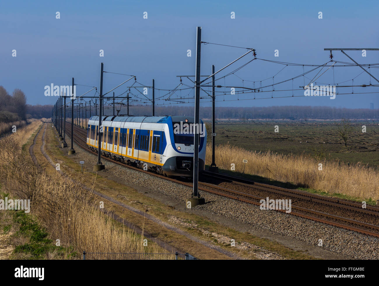 Flevoland, the Netherlands - March 26, 2016: Dutch snel train traveling through countryside. Stock Photo