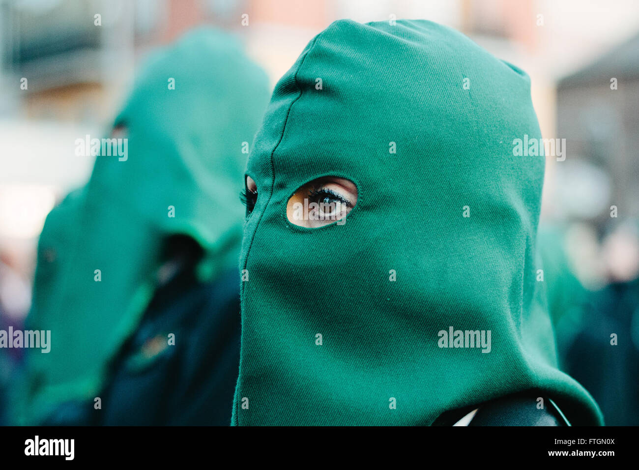 Portrait of a woman wearing a green hood during a procession. Holly Week, Spain. Cofradía María del Dulce Nombre. Stock Photo