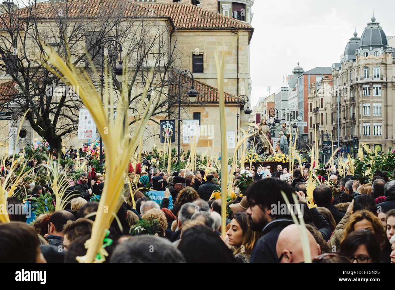 Palm Sunday procession in León, Spain. People carrying palms and looking at the float with Jesus and the donkey. Stock Photo