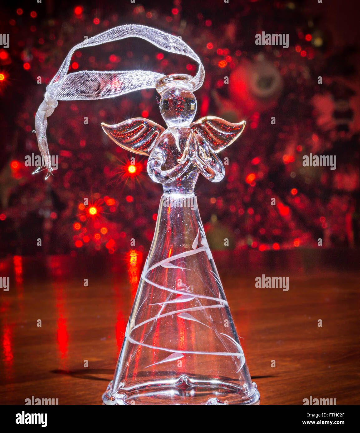 Glass angel Christmas Tree decoration, with tree in background Stock