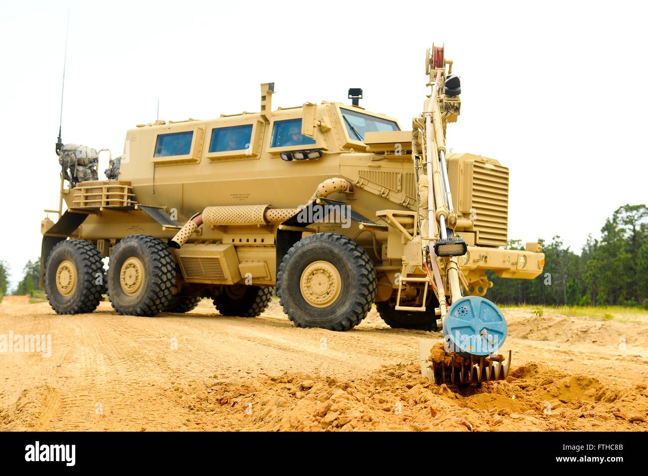 A U.S. Army Buffalo explosive device detection vehicle digs up an improvised explosive device using the robotic arm during route clearance operations training at McCrady Training Center June 24, 2014 in Eastover, South Carolina. Stock Photo