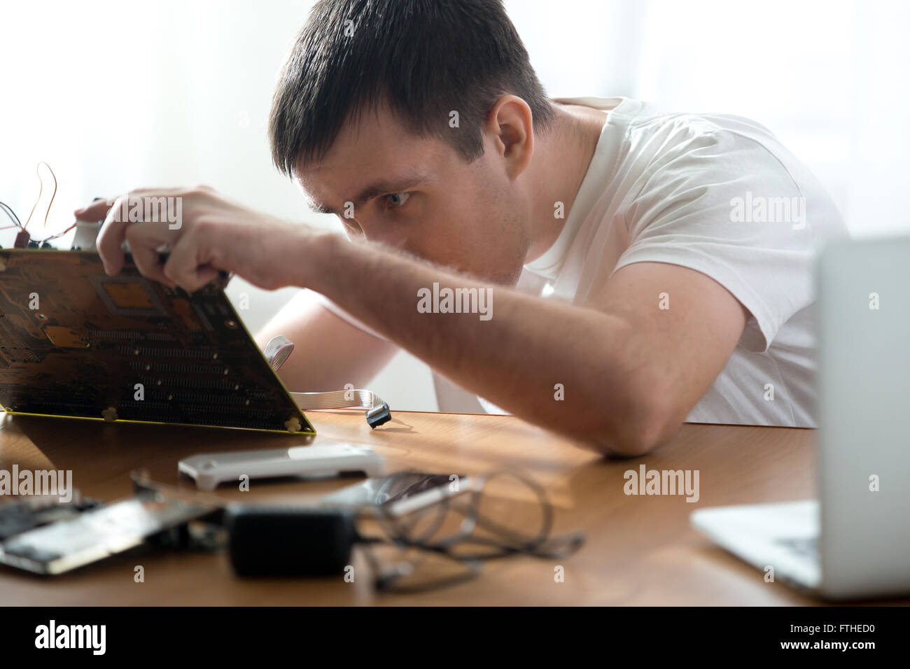 Portrait of technician repairing broken computer parts indoors at the