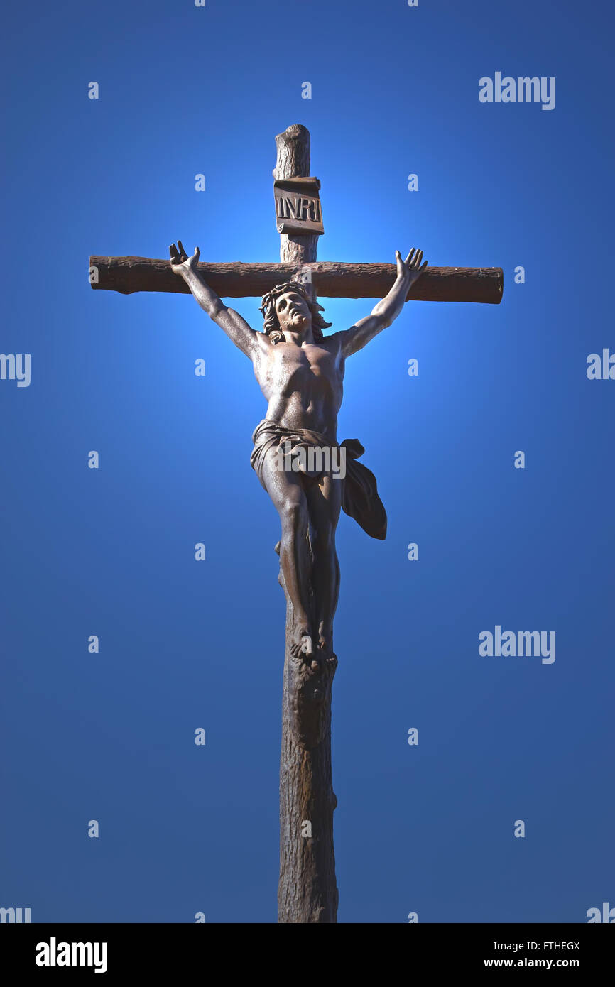 Statue of Jesus Christ on a cross. Blue sky in the background ...