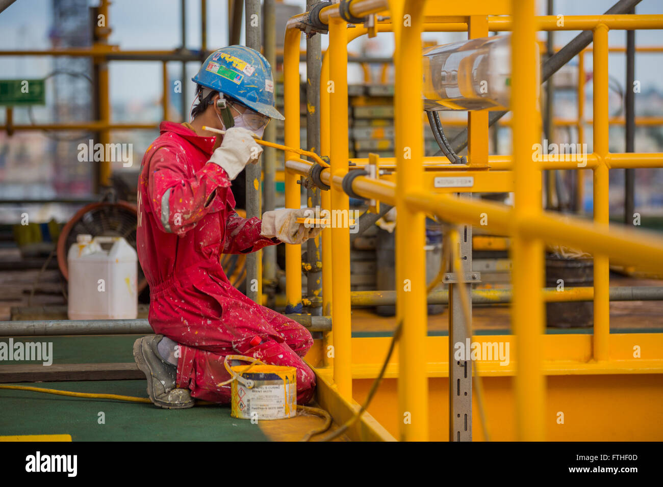 Man painting an oil rig Stock Photo