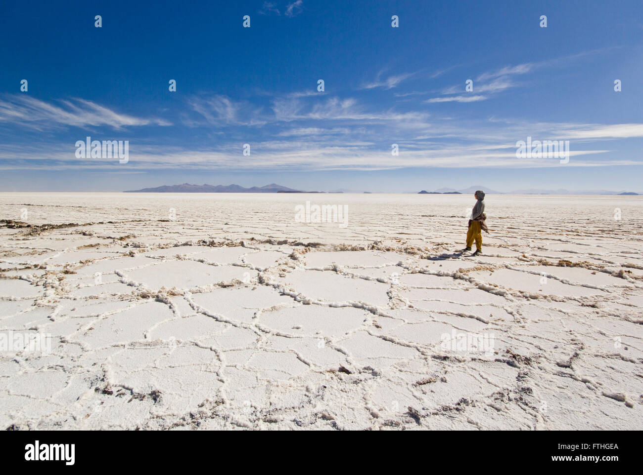 girl standing on salt of salar de uyuni and looking to horison Stock Photo