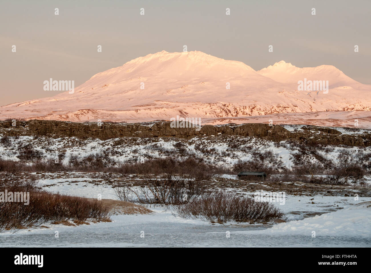 Pink-tinged snow covered mountains at sunrise, Golden Circle, Iceland Stock Photo