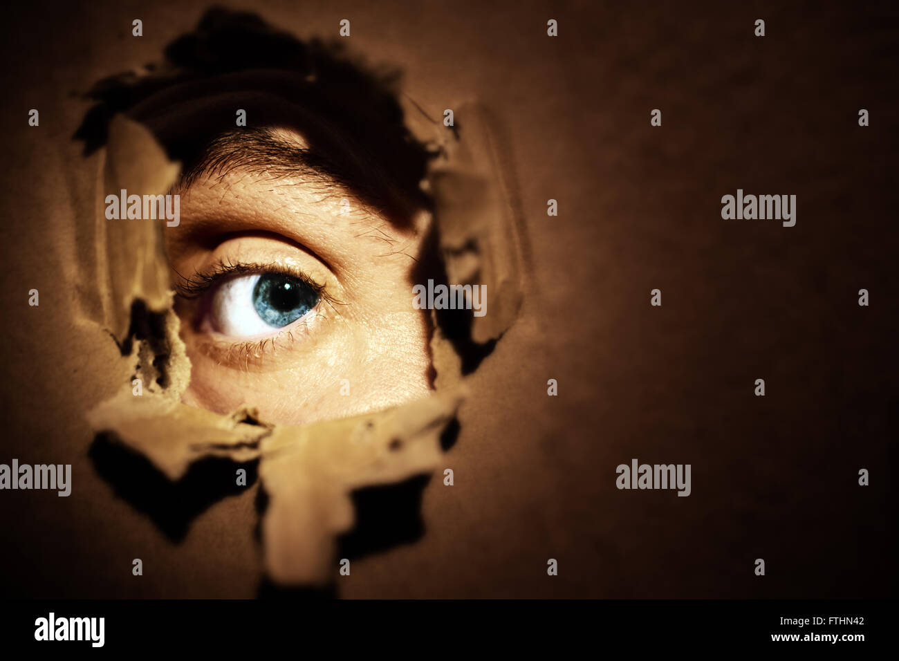 Male eyes spying through a hole in the wall Stock Photo Alamy