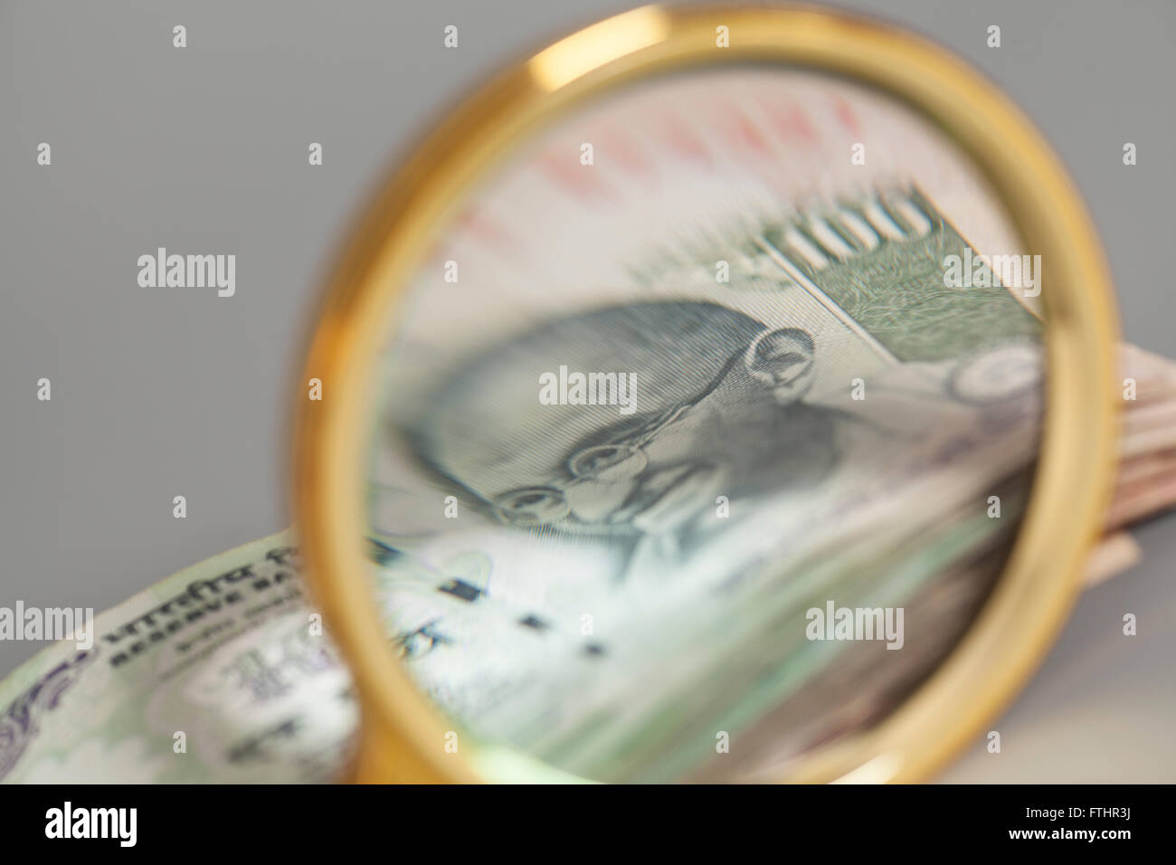 Indian Currency Rupee Notes with magnifying glass on gray Stock Photo ...
