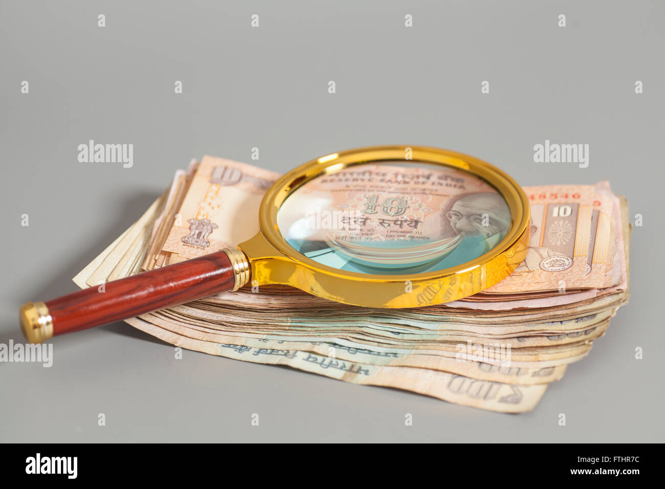 Indian Currency Rupee Notes with magnifying glass on gray Stock Photo ...