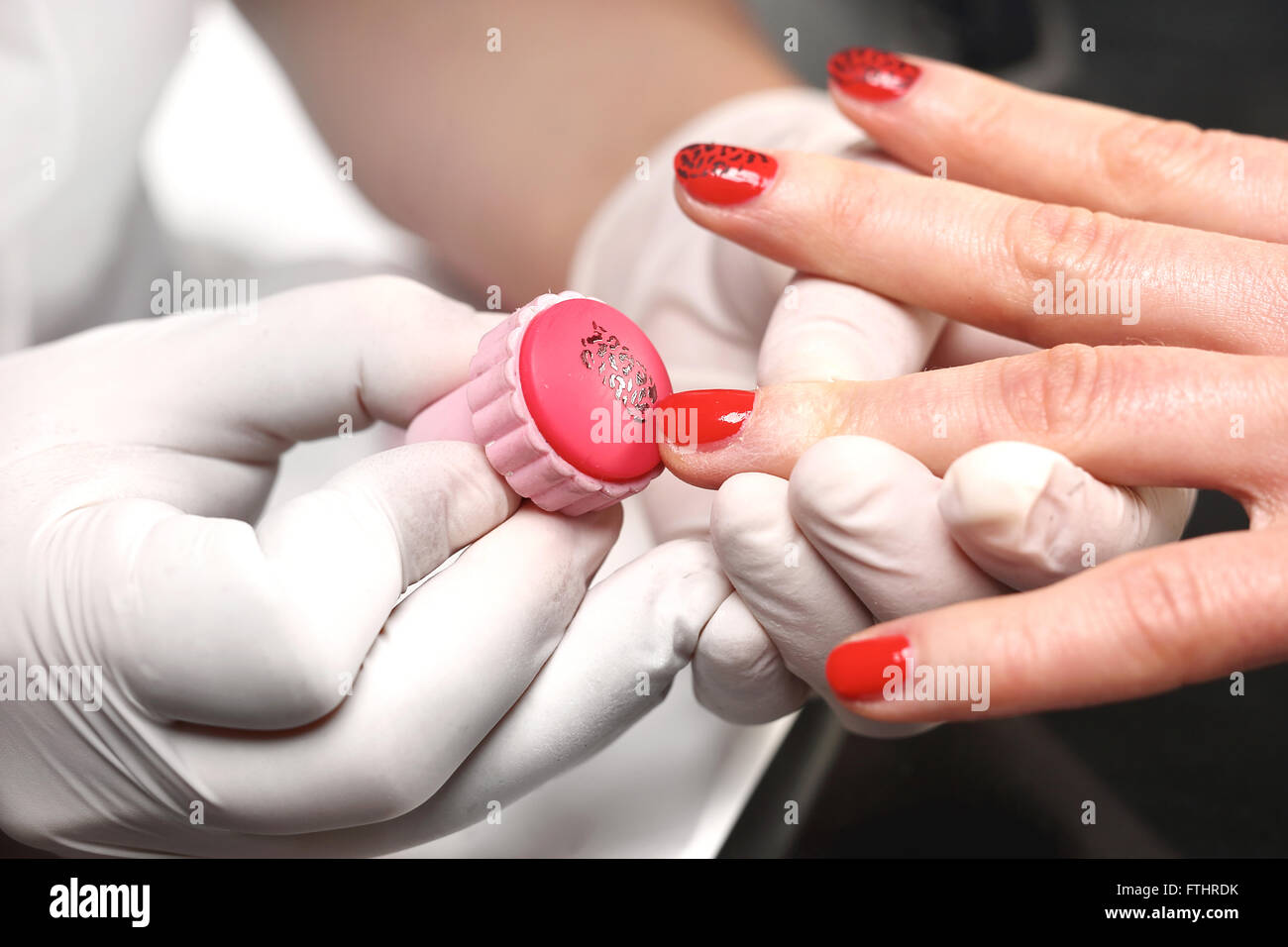 Stamps nail beautician applies the lacquer on plaque. Decorating nails, stamped method. Manicure, patterns on nails Stock Photo