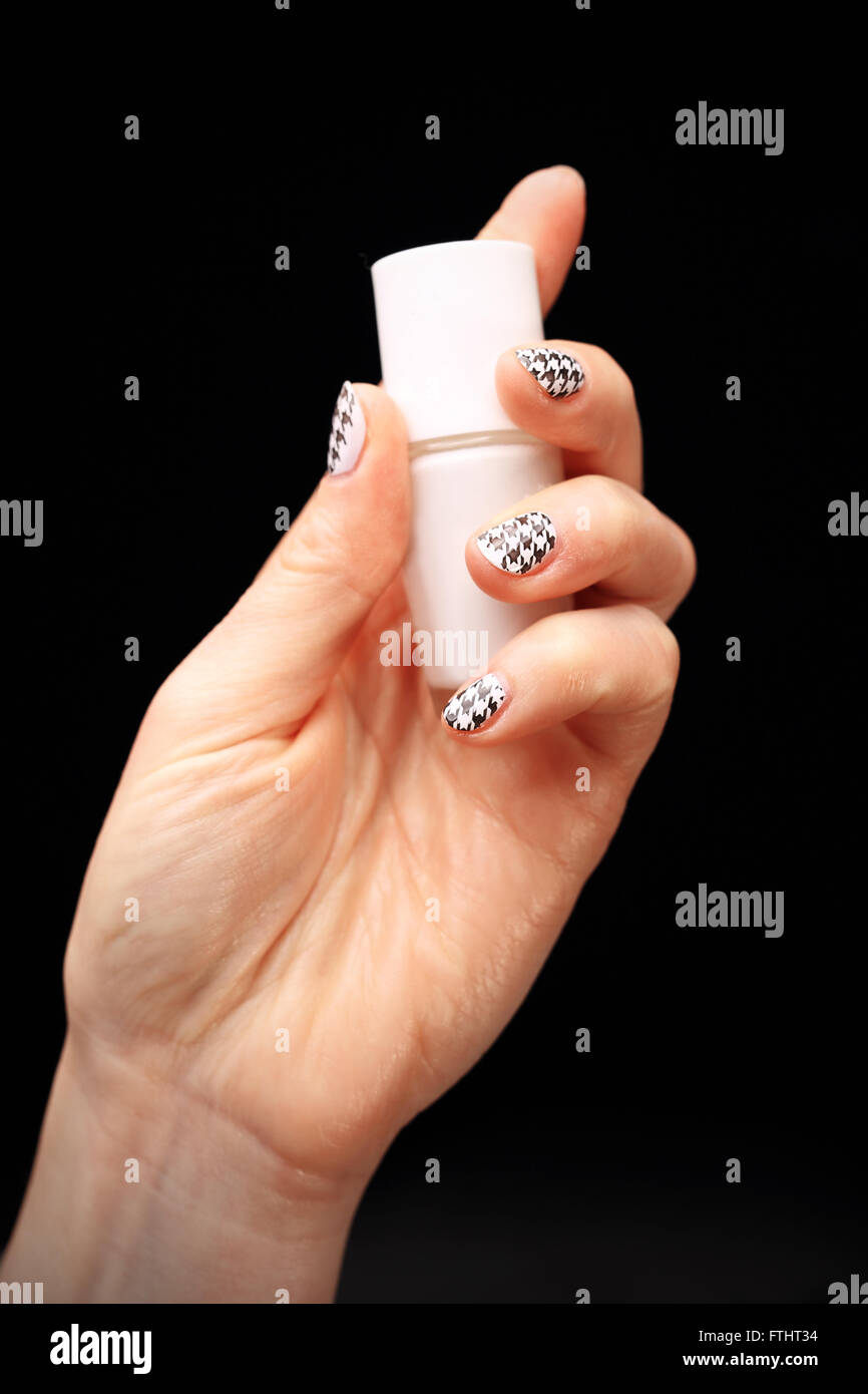 Crazy manicure, black and white grid. Woman's hand with fingernails painted in black and white checkered Stock Photo