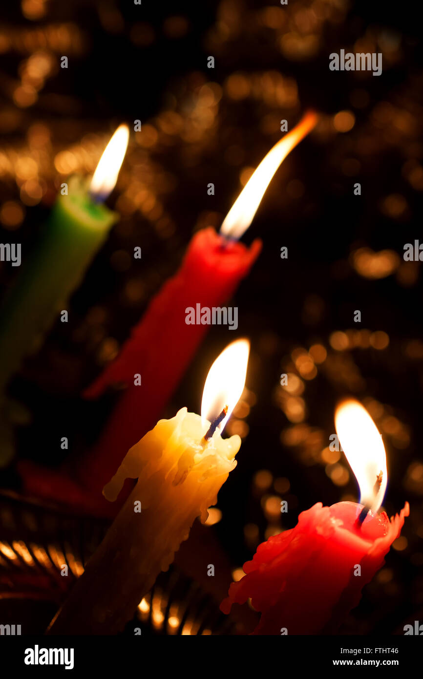 Four candles burning in the darkness closeup Stock Photo Alamy