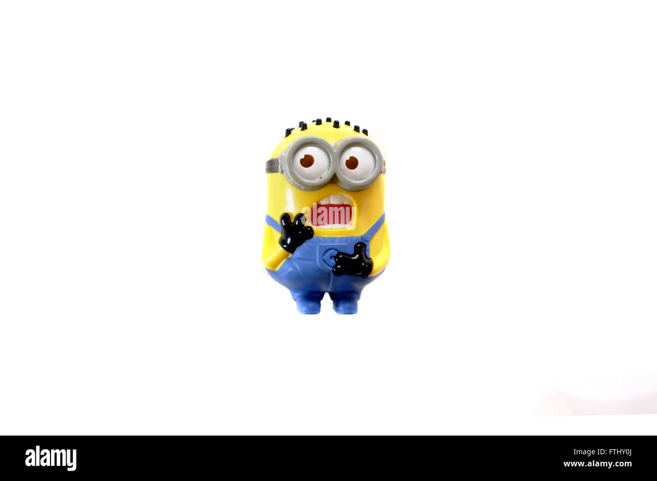 A front view of a toy figure from the Minions film photographed against a white background. Stock Photo