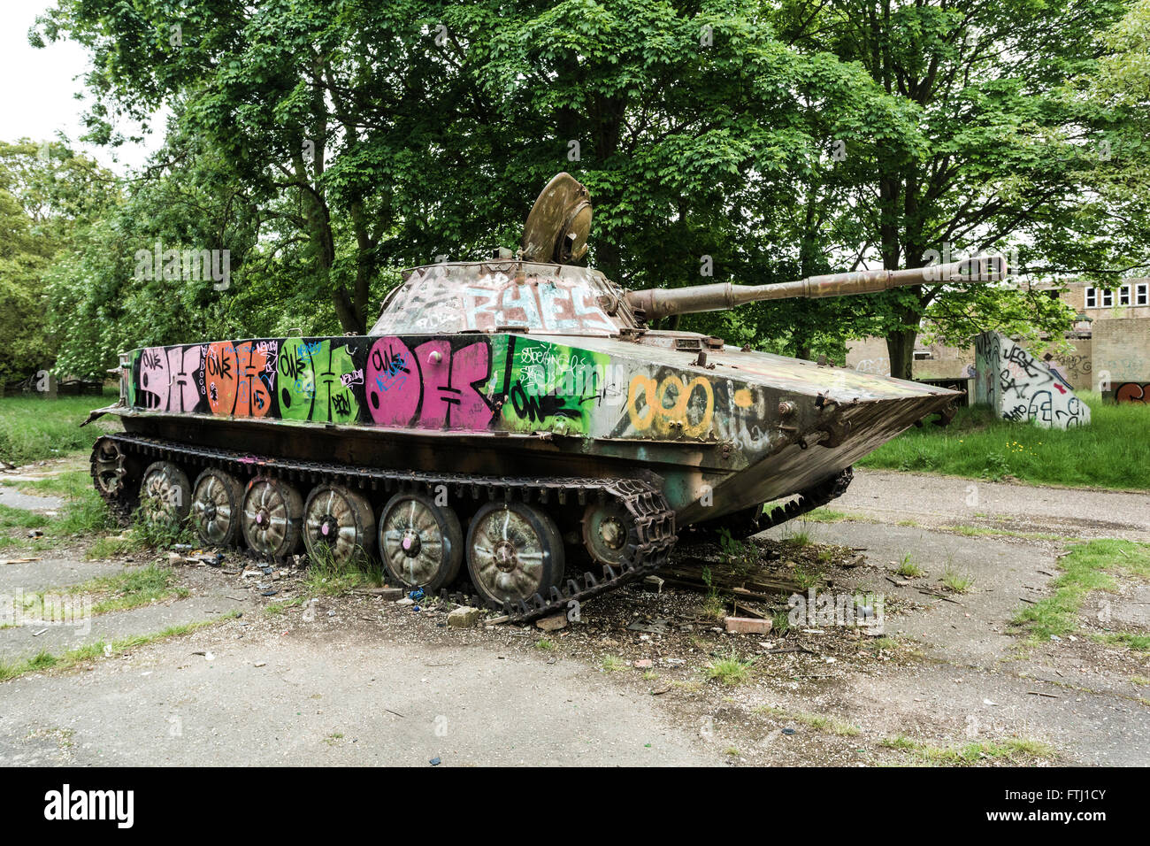 military tank with graffiti painted on at the old derelict RAF Upwood airbase in Cambridgeshire, UK Stock Photo