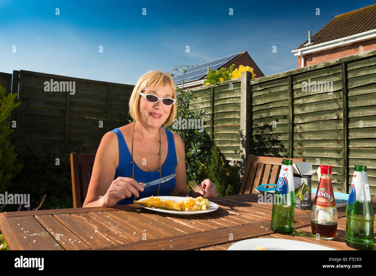 woman eating meal outdoors at home Stock Photo