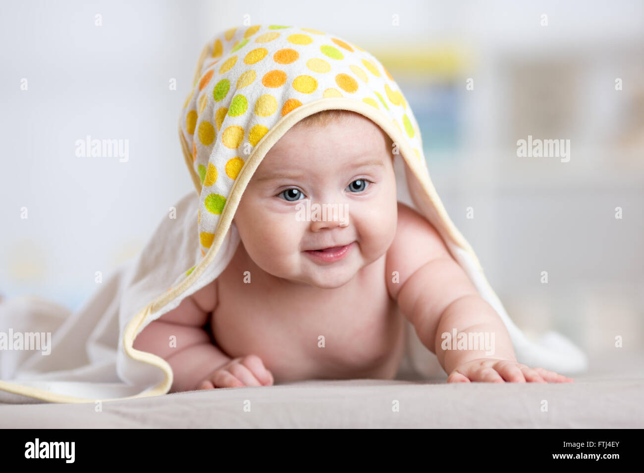 Adorable happy baby in towel indoor Stock Photo