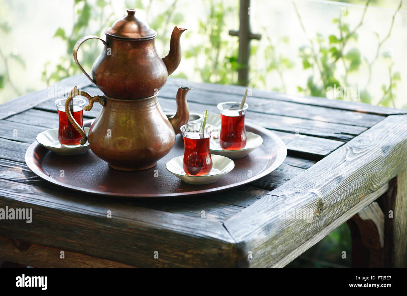 Traditional copper Turkish teapot in summer outdoor cafe Stock Photo