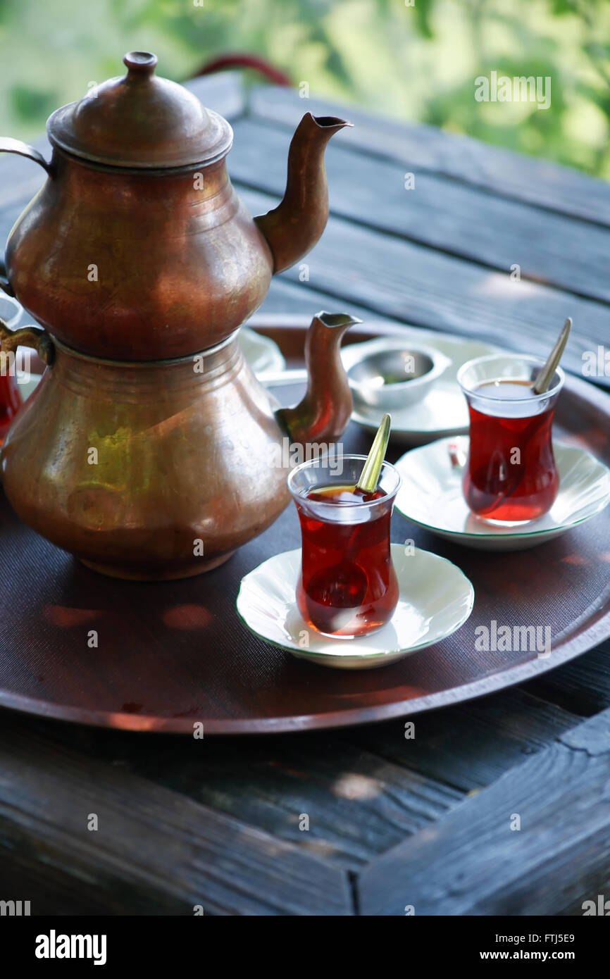 Traditional copper Turkish teapot in summer outdoor cafe Stock Photo