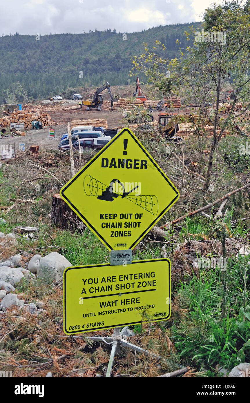 Signage warns visitors to keep clear of machinery used for felling trees in case a chain saw breaks. Stock Photo
