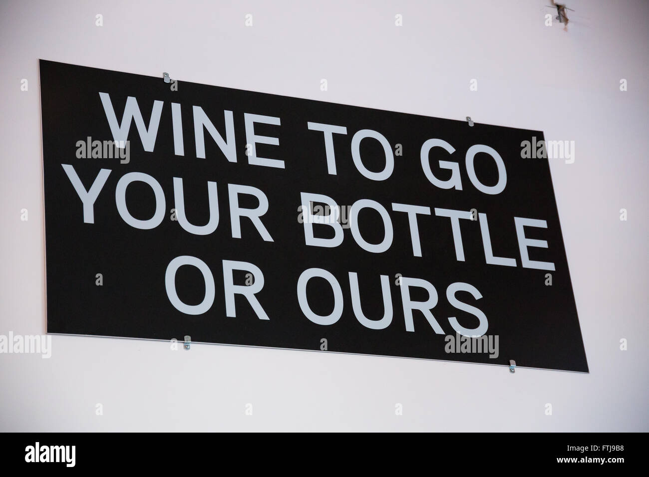 Winery that sells growler fills of wine has a sign that says wine to go your bottle or ours. Stock Photo