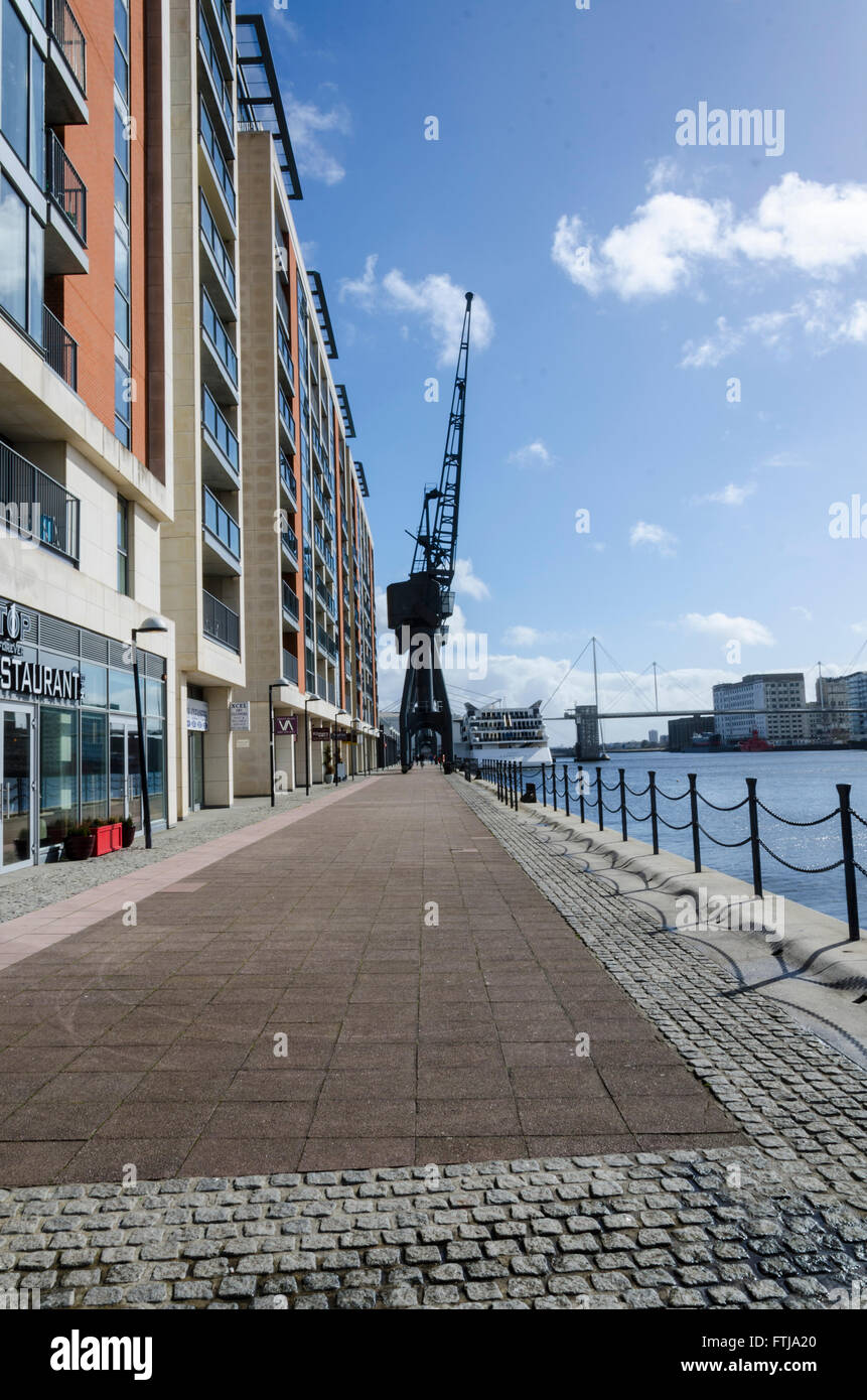 Looking along the bank of The Royal Victoria Dock. An old crane in the distance reminds visitors of the area's history. Stock Photo