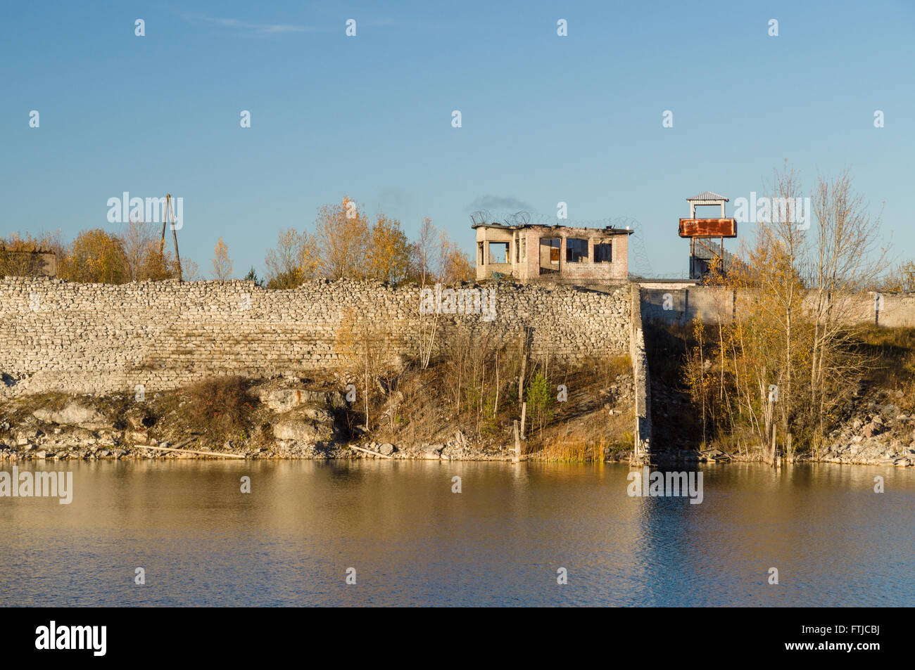 Abandoned prison barbed wire wall and watch tower Stock Photo