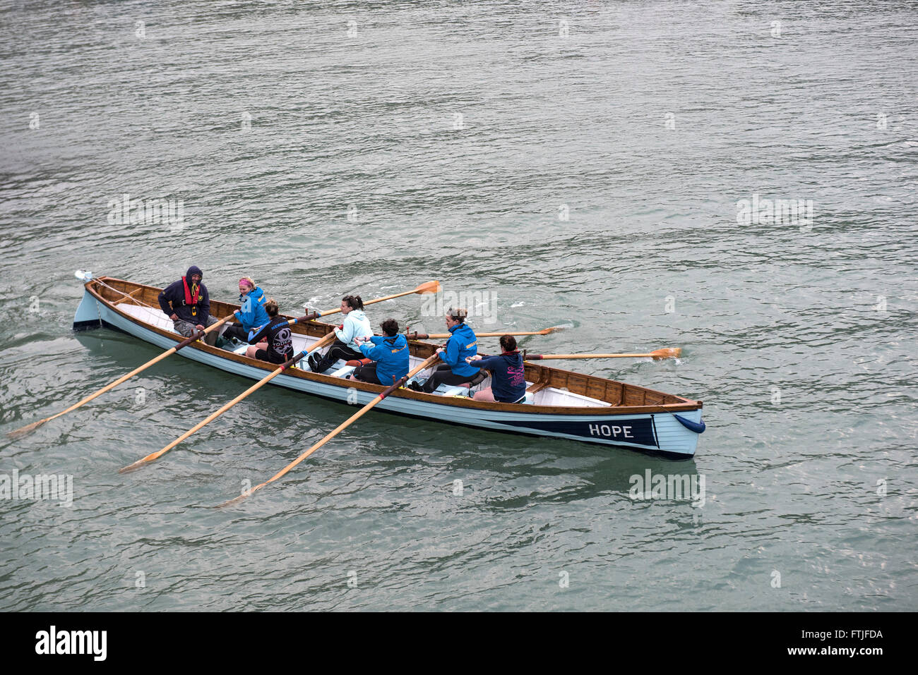 Hope, a traditional Cornish racing gig is rowed out of Newquay Harbour by its all female crew. Stock Photo