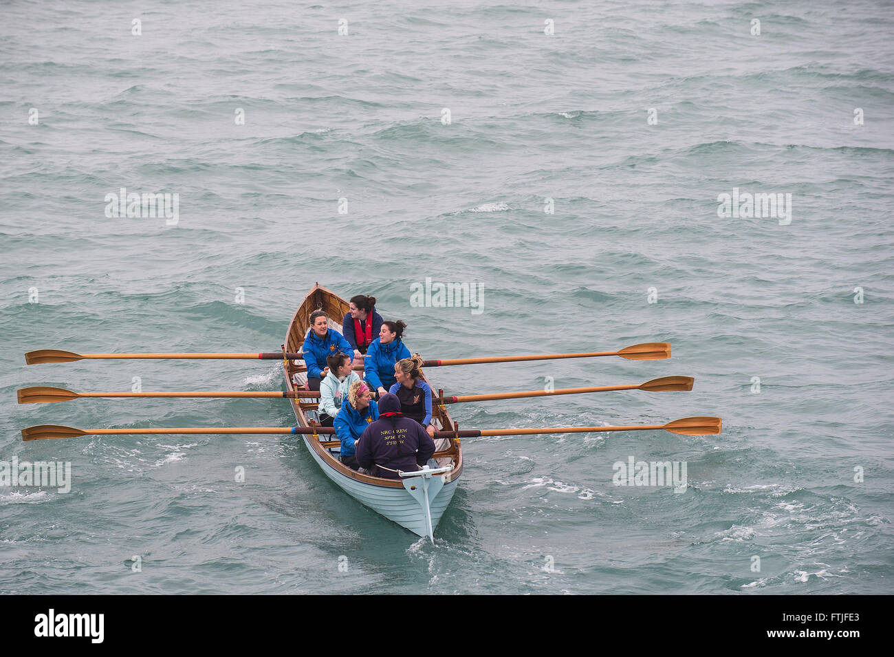 Hope, a traditional Cornish racing gig is rowed out to sea from Newquay Harbour by its all female crew. Stock Photo