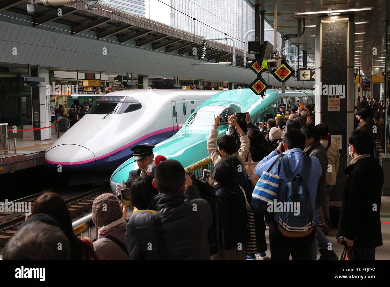 People take pictures of the Hayabusa Shinkansen (bullet train) in Tokyo ...