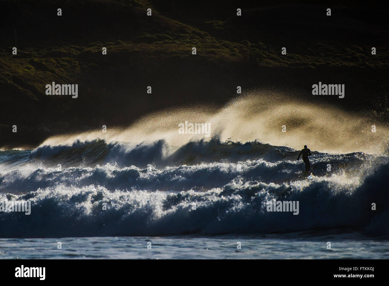 Surfing UK.  A lone surfer rides rough waves at Fistral in Newquay, Cornwall Stock Photo