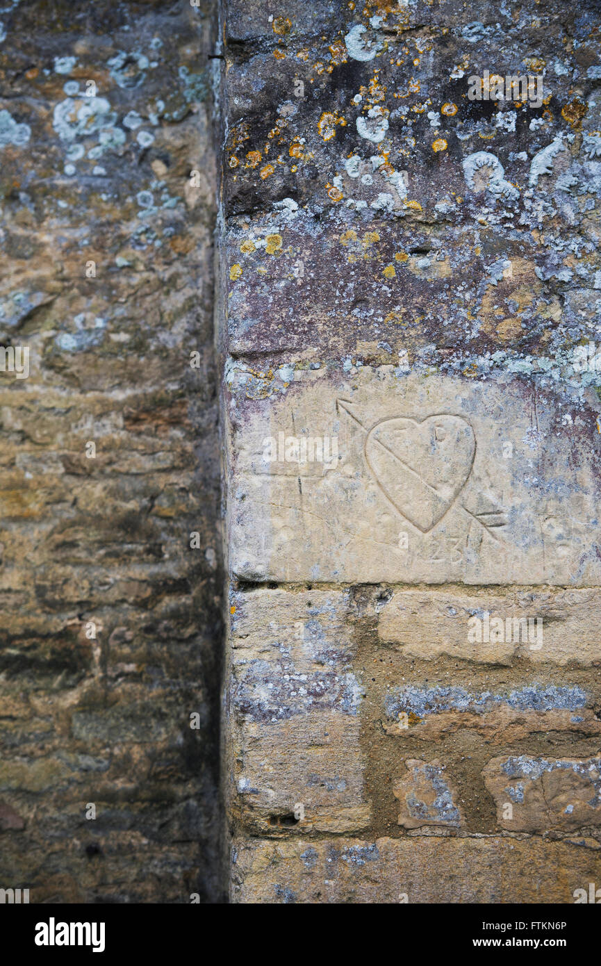 Carved love heart on a cotswold stone wall. Bibury, Gloucestershire, England Stock Photo