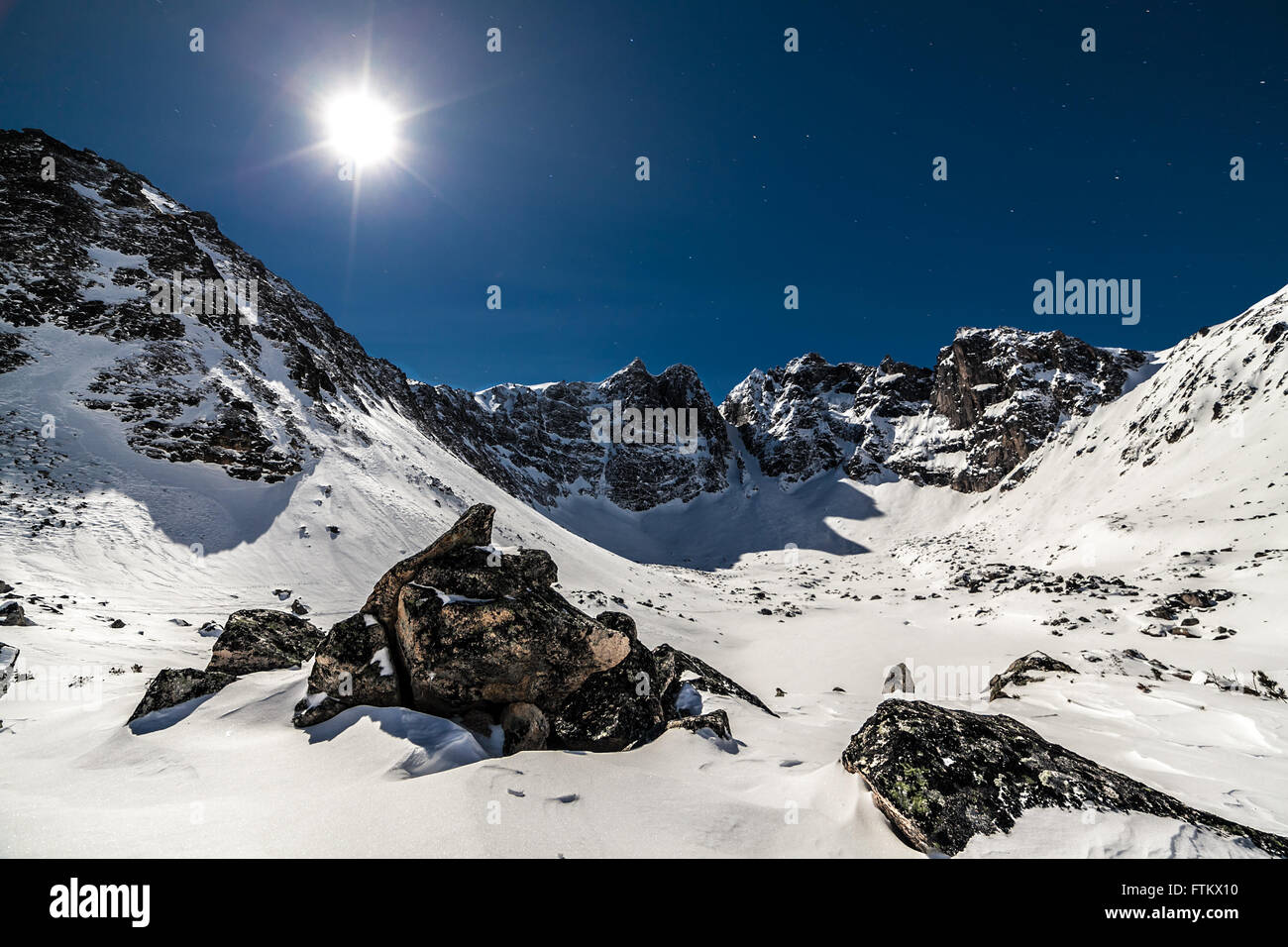 Bright sun over the high snow mountains Stock Photo - Alamy