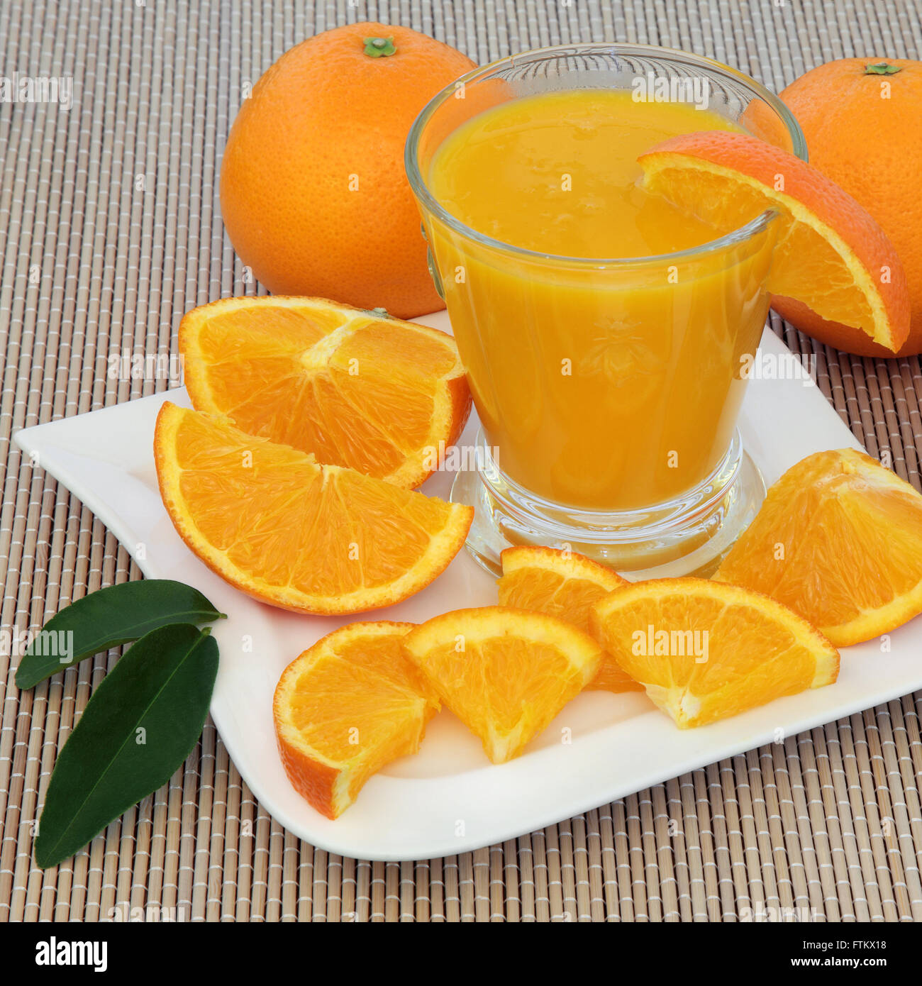 Healthy fresh orange drink with oranges high in vitamin c and antioxidants over bamboo