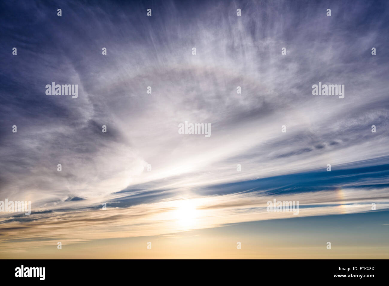 Sun halo and Cirrostratus clouds at sunset. Stock Photo