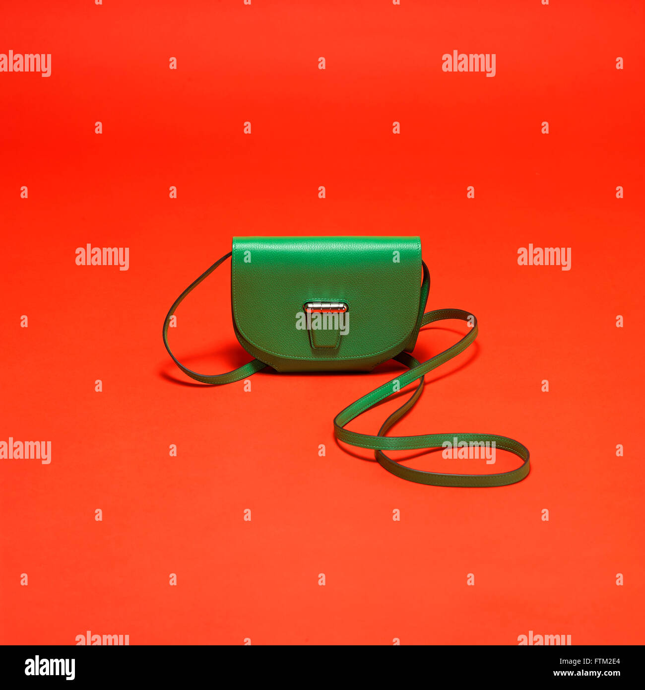 Green leather bag on an orange background Stock Photo