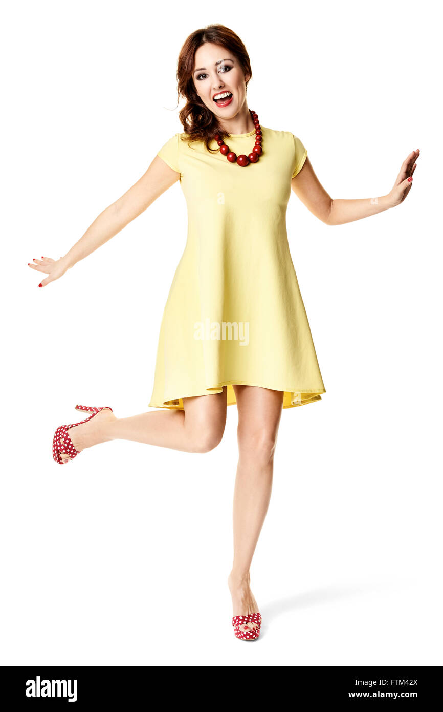 Happiness woman in yellow dress dancing. Studio shot isolated on white background. Stock Photo